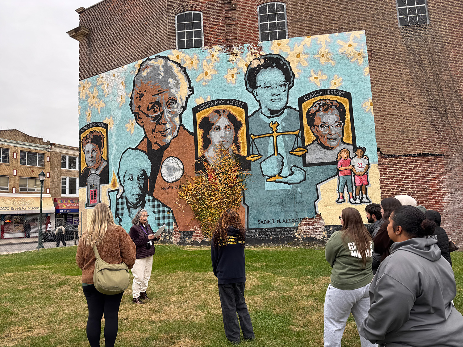 ED308 students listening to a mural tour guide.