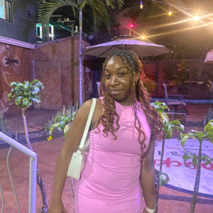 Azariah Giddings ’27 standing in front of a palm tree.