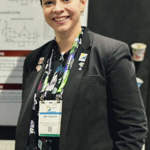 Amy Stringer ’20, ’21M, standing in front of a presentation board.