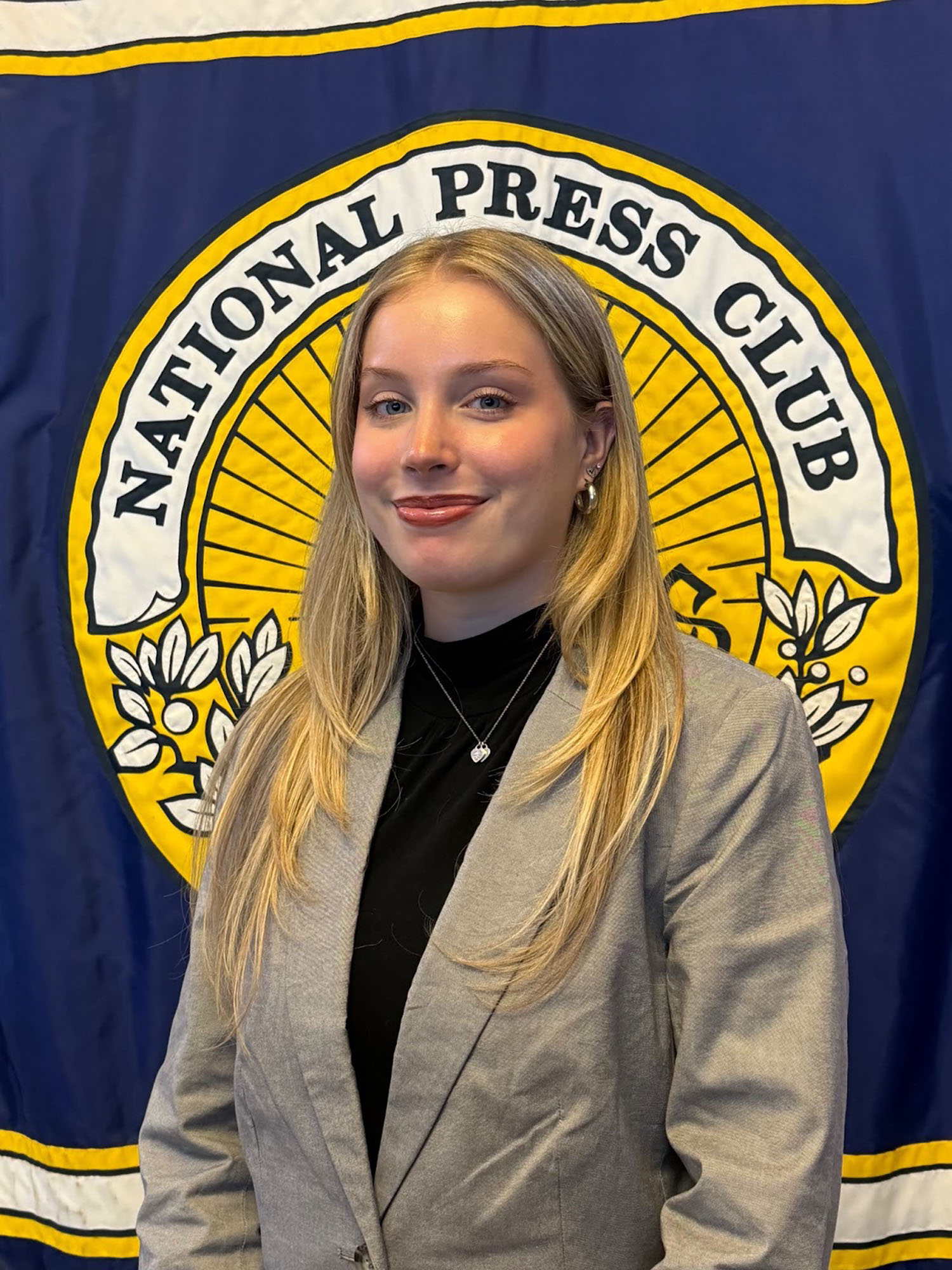 Lily Roberti ’28 in front of a banner reading "National Press Club."