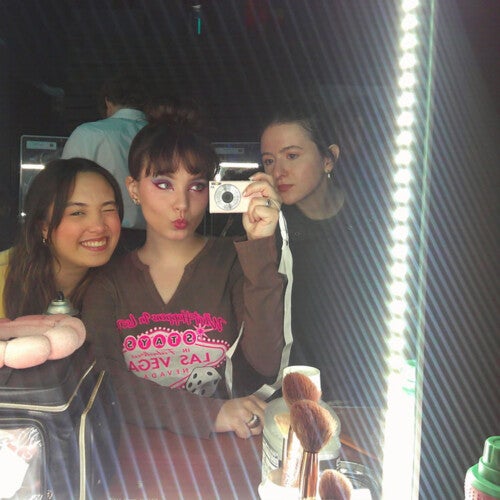 Zara Peters ’26 and other cast members in a mirror before a rehearsal.