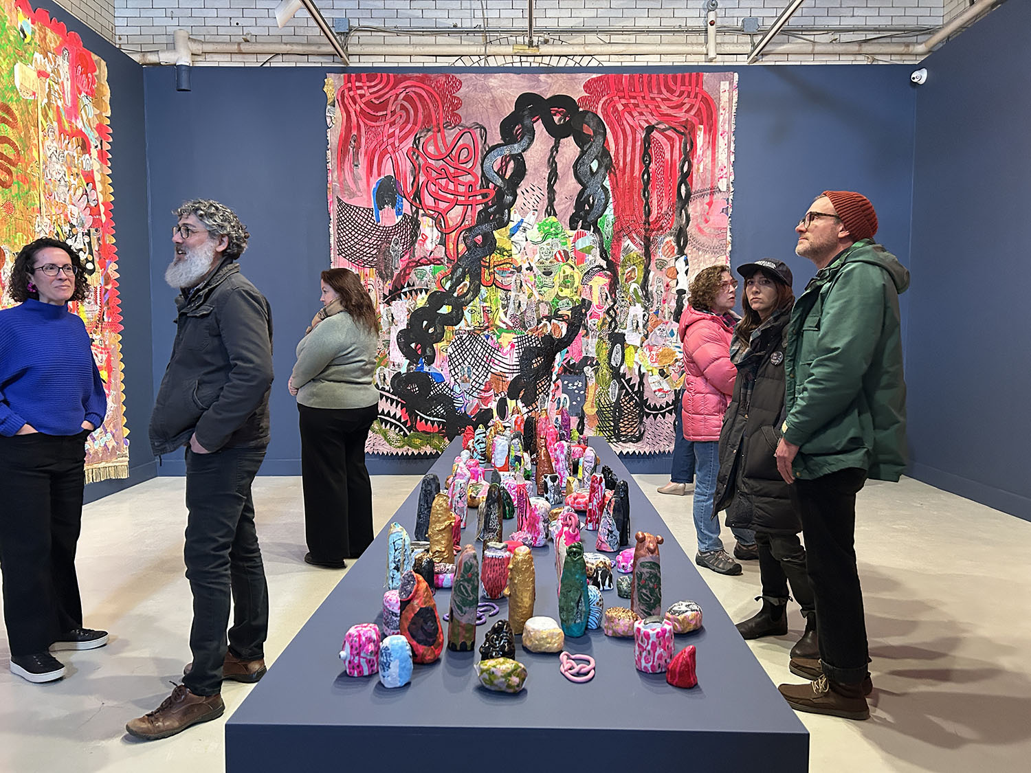 Guests examining the artwork at the exhibition opening.