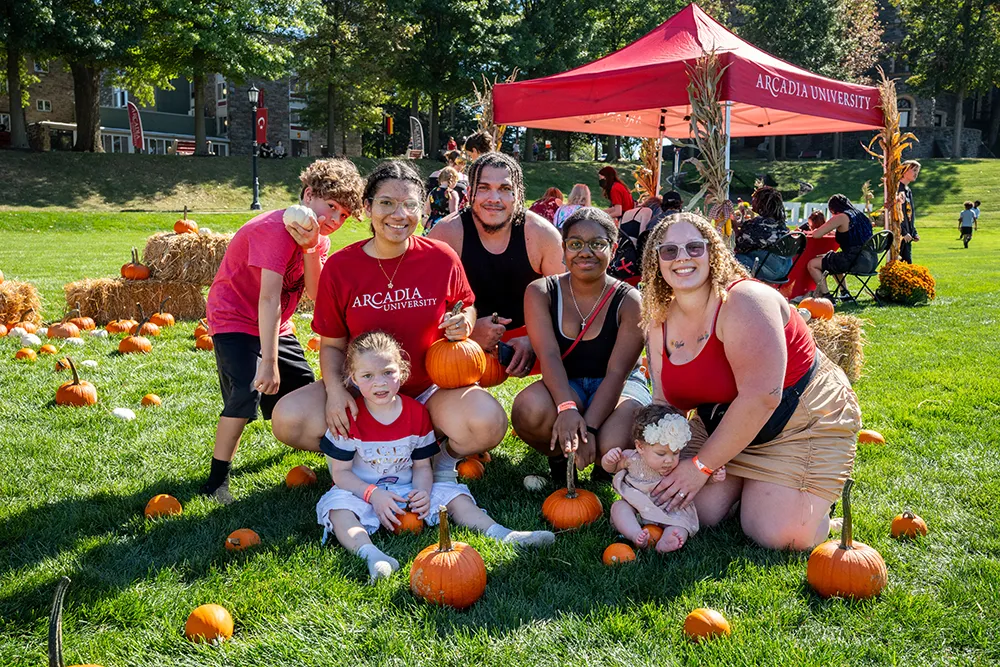 A family gathers around a pumpkin patch during Homecoming & Family Weekend.
