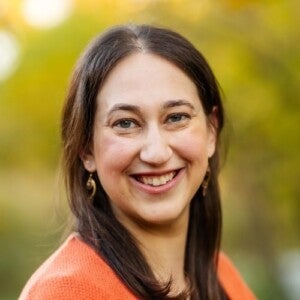 Prof. Karen Schwartz's headshot. She has brown hair and an orange shirt on. She is smiling.