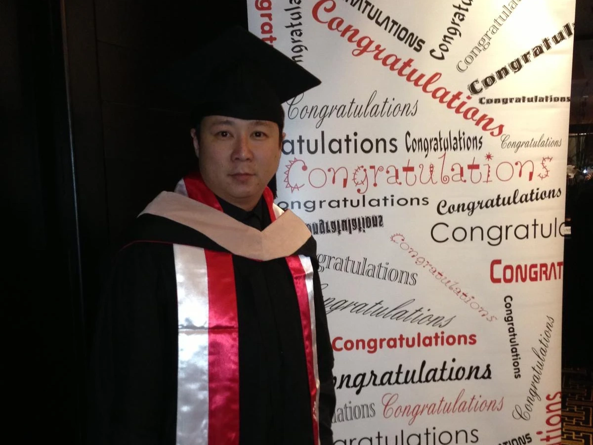 Tan Teck Leng '12MBA poses for a photo in his cap and gown at graduation.