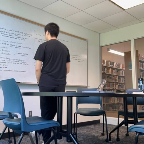 Chayhok Chhor ’27 looking at notes on a white board.