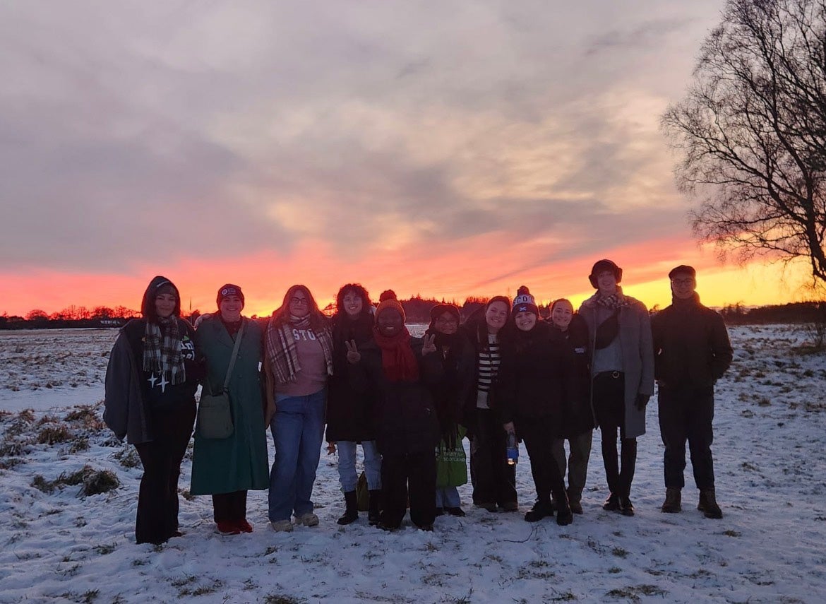 JJ Demetrius ’26 and their classmates standing in the snow.