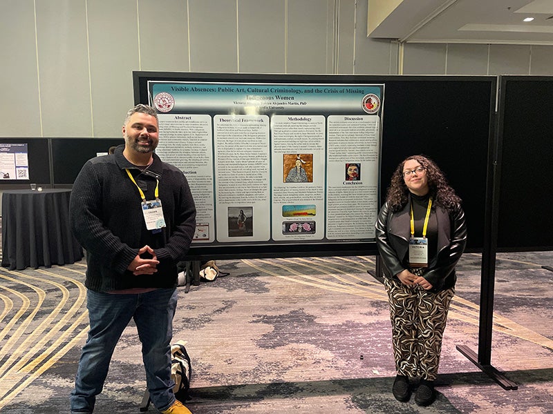 Dr. Favian Martin and Victoria Rivera pose in front of their research poster.