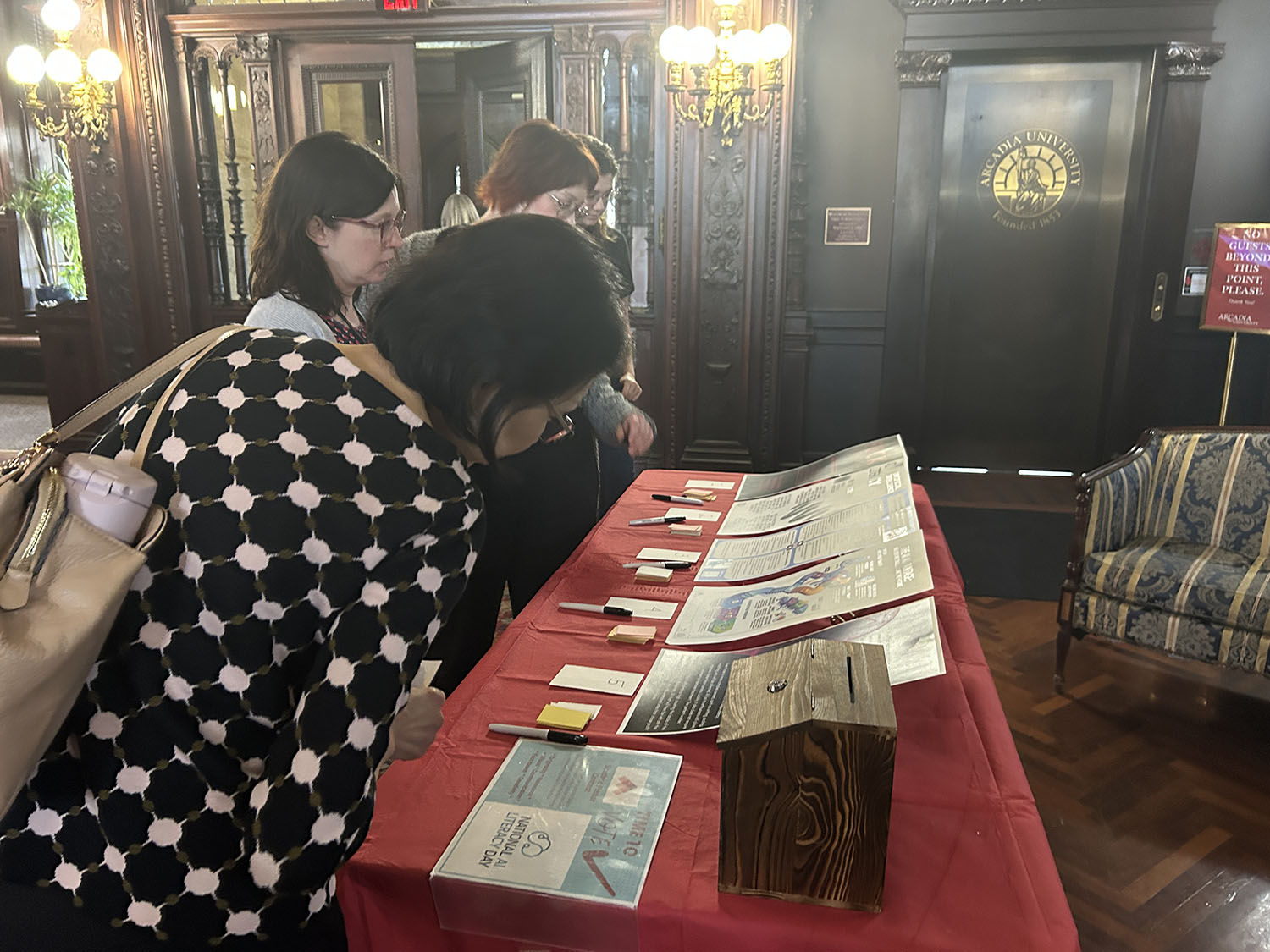 Faculty members looking at the student posters during AI Literacy Day.