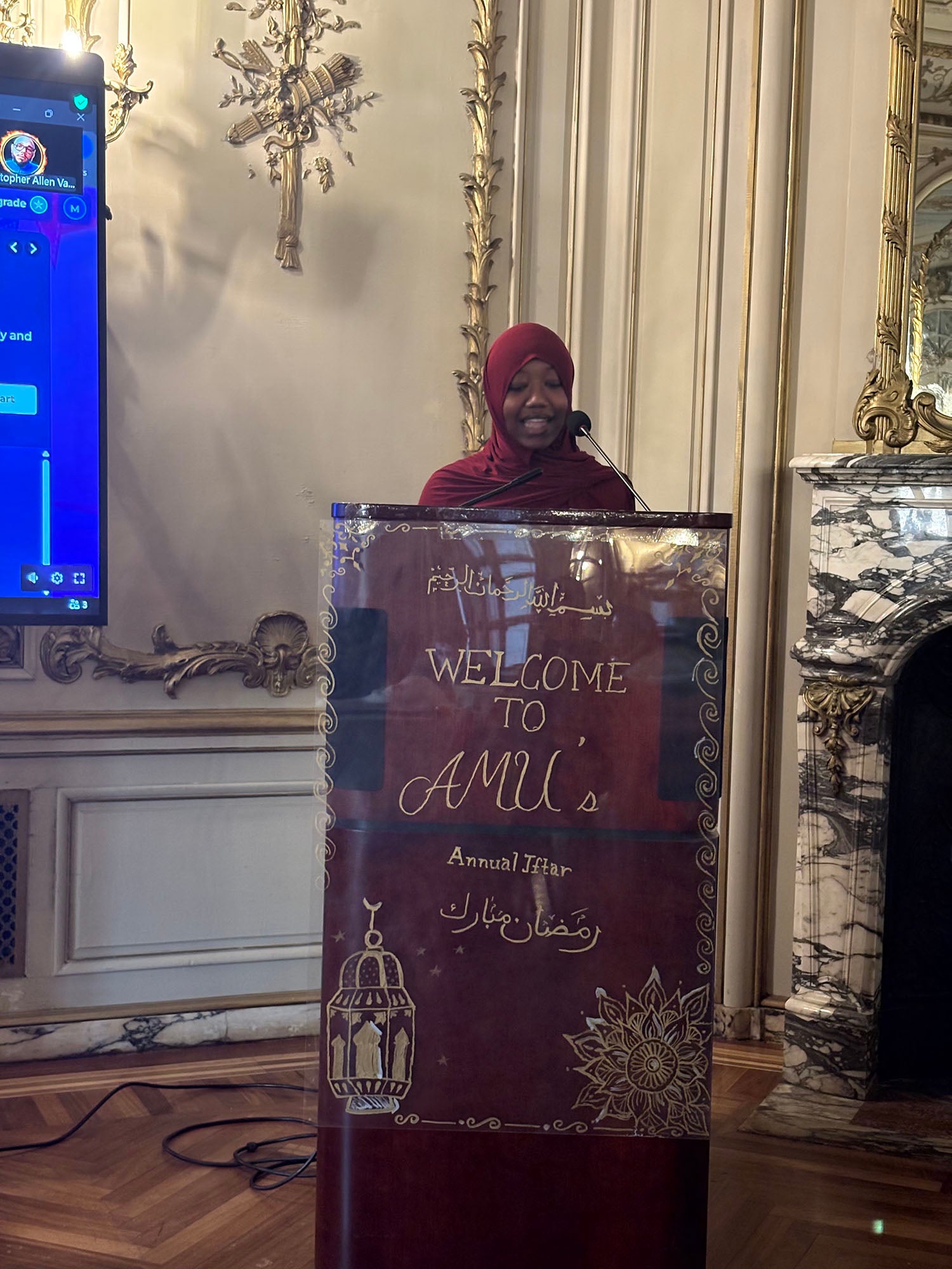 Hajr Washington ’26 speaking at the podium during AMU's Iftar.