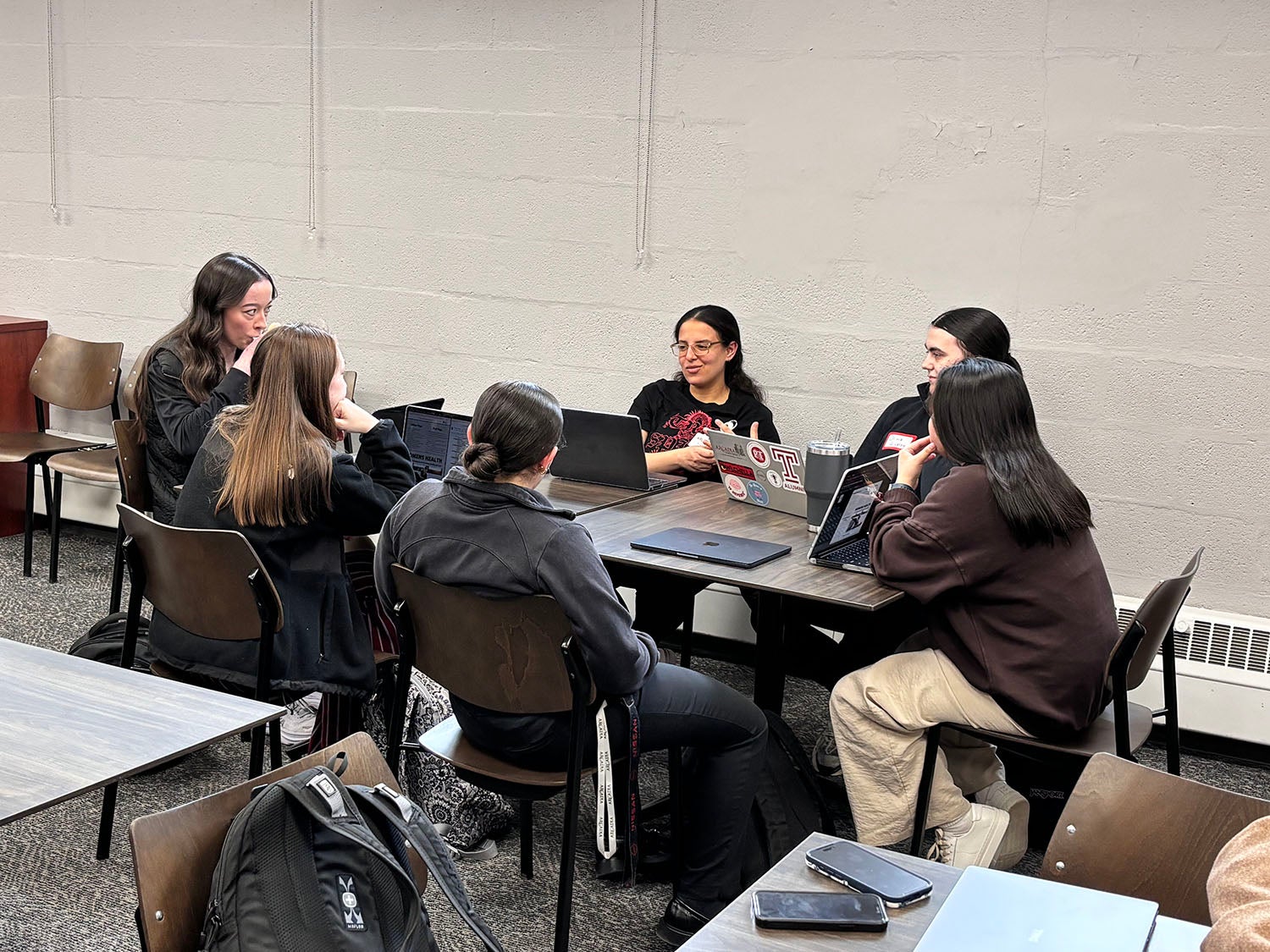 CHS students discussing topics around a table.