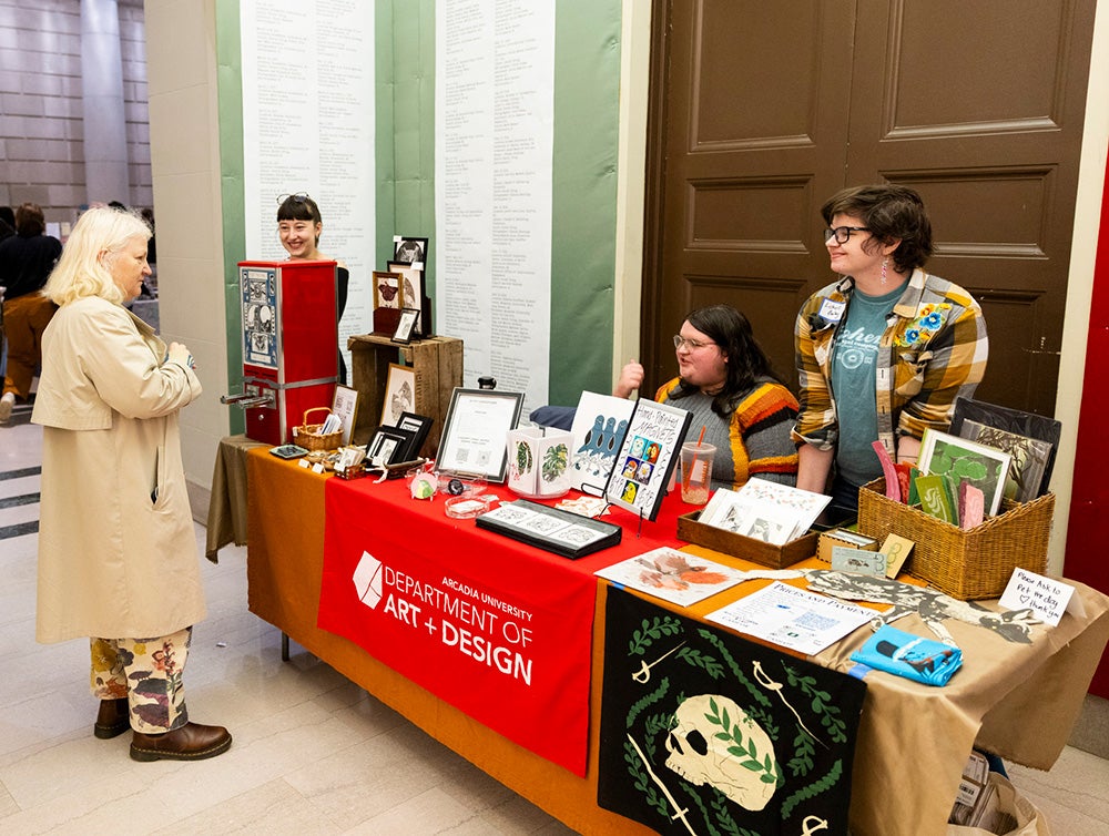Gertie Smith ’27, Willow Edmonds ’26, and Lichen Balay ’25 staff the Arcadia Department of Art and Design table at last year's printPHILLY!