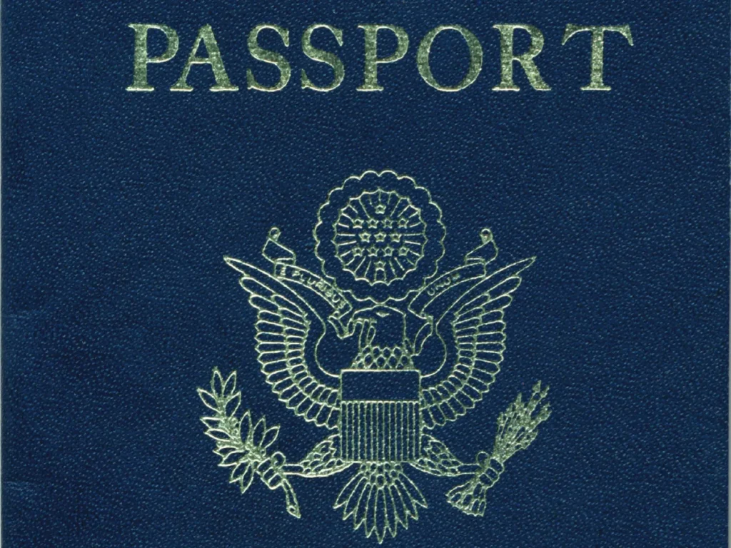 A closeup of a blue US passport showing the word Passport and the passport's official seal.