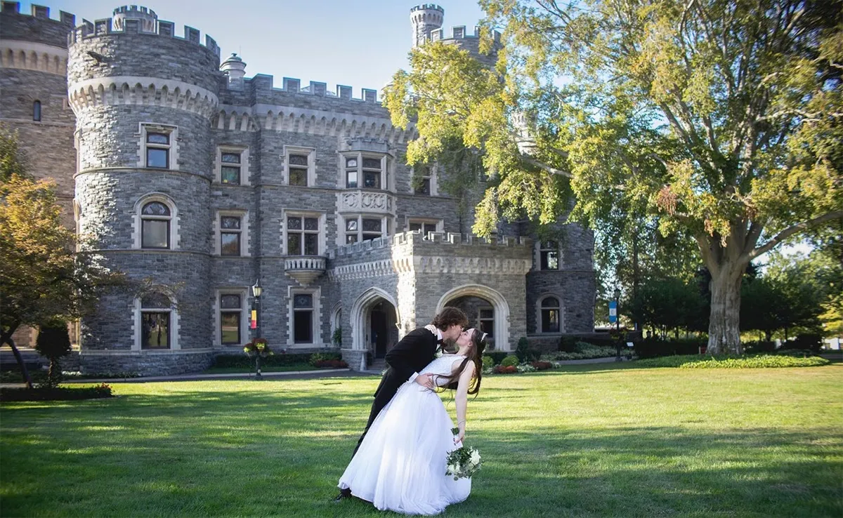 A formerly dressed couple celebrates their wedding in front of the castle.