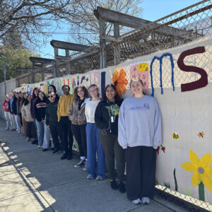 Students from the Craftivism class standing in front of their project.