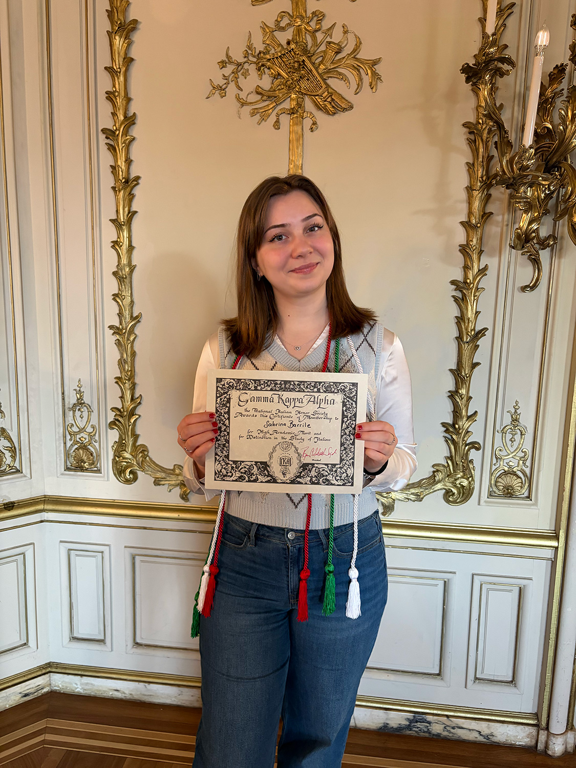 Sabrina Barrile ’26 holding a certificate from Gamma Kappa Alpha.