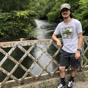 Patrick Hood ’26 on a bridge with a creek in the background.