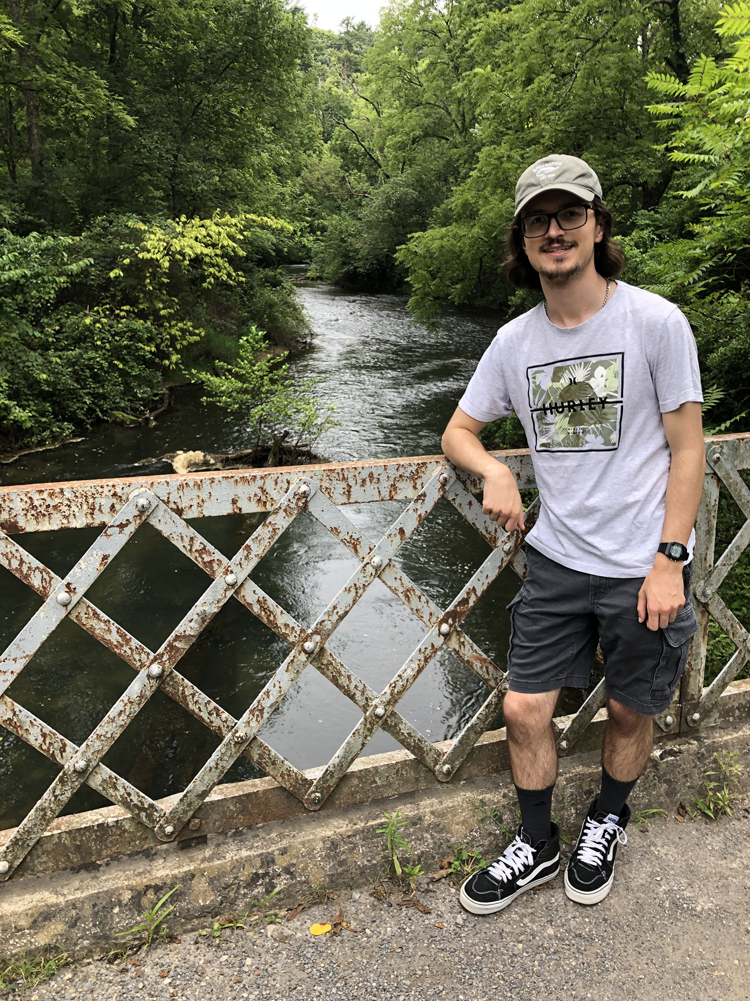 Patrick Hood ’26 on a bridge with a creek in the background.