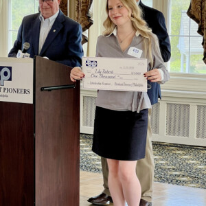 Lily Roberti ’28 holding her check from the Broadcast Pioneers of Philadelphia.