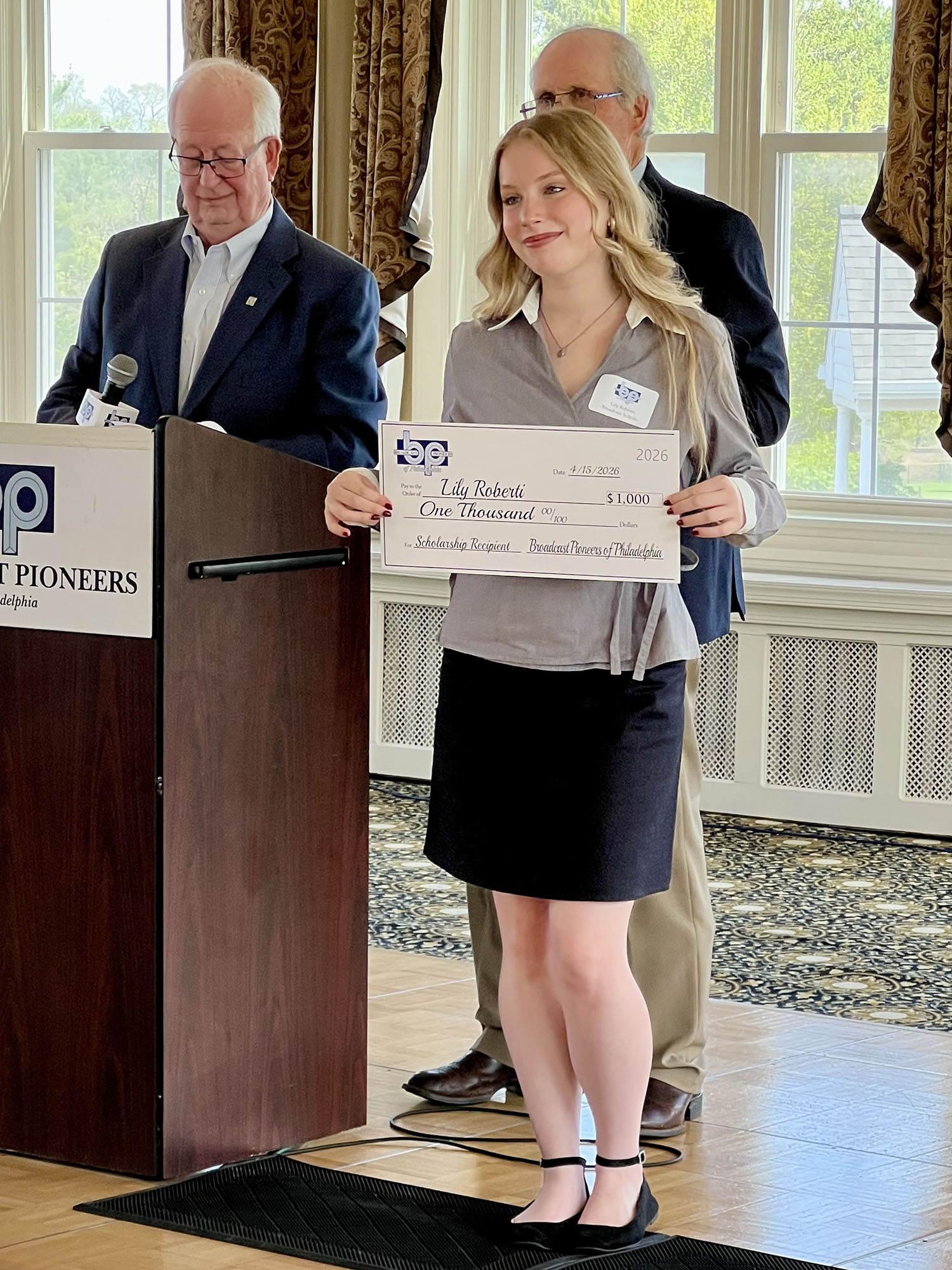 Lily Roberti ’28 holding her check from the Broadcast Pioneers of Philadelphia.