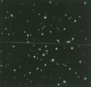 Photo of a black background with white specs representing stars.