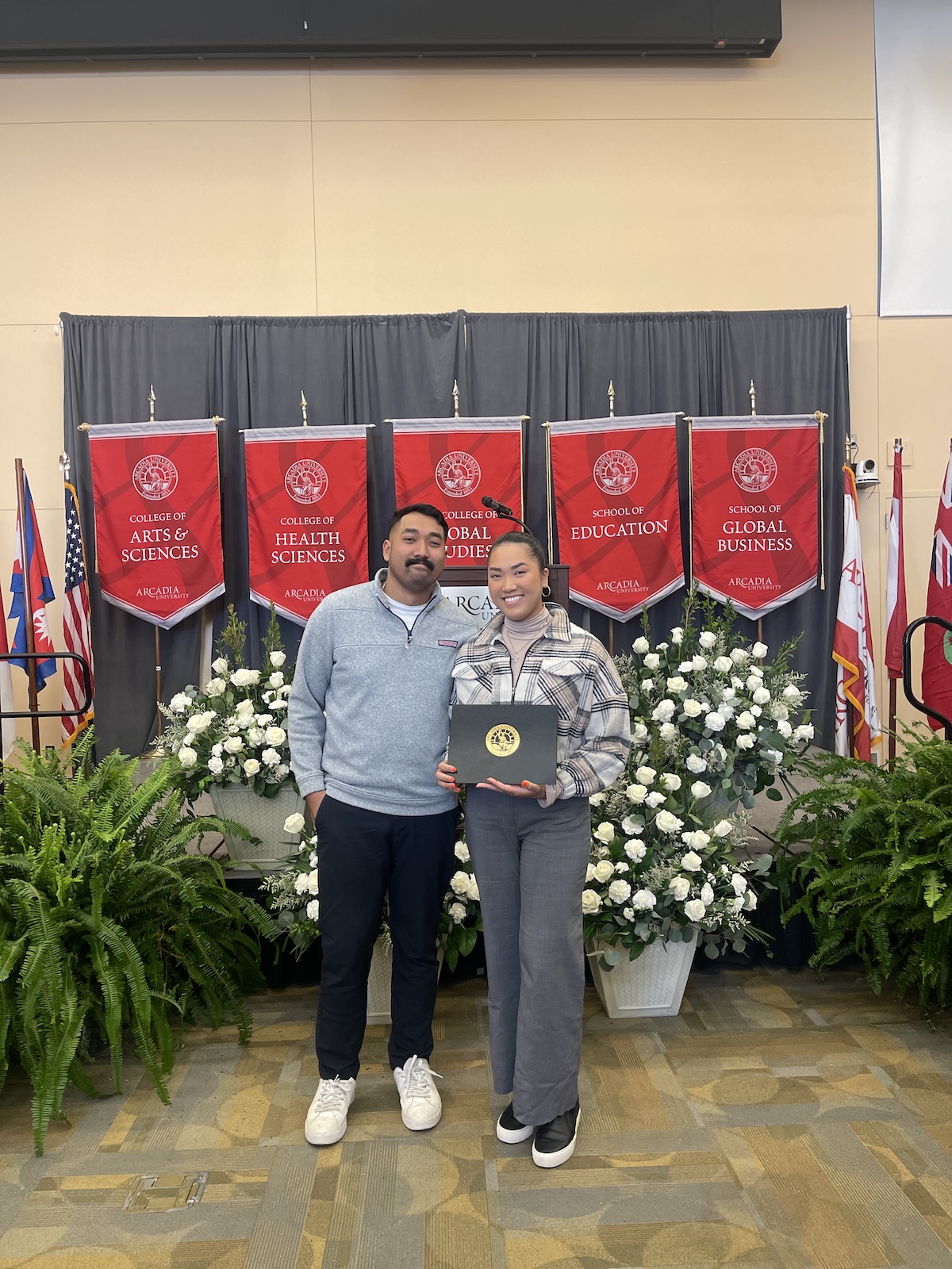 Karen Hua holds a certificate in front of the stage at the 2026 Honors Convocation award ceremony