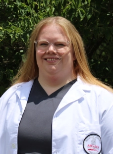 Honors Convocation 2026 award recipient Amalia Jording stands outside in her white coat and smiles.