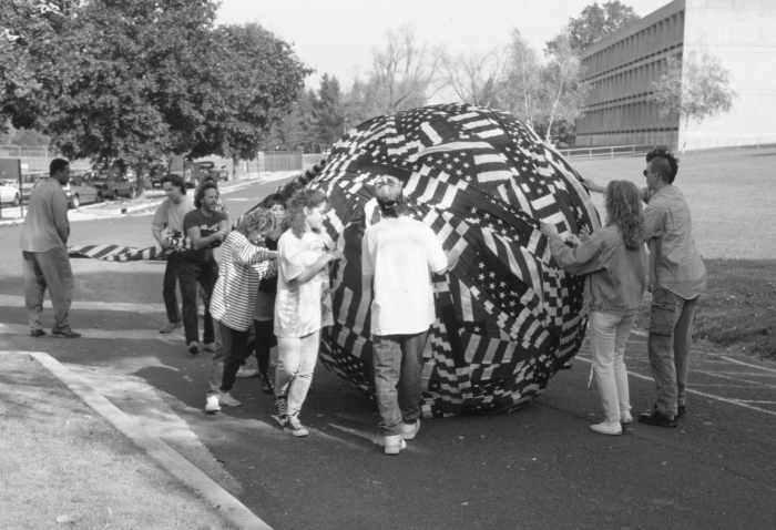 Black and white photo of people holding a ball of American flags