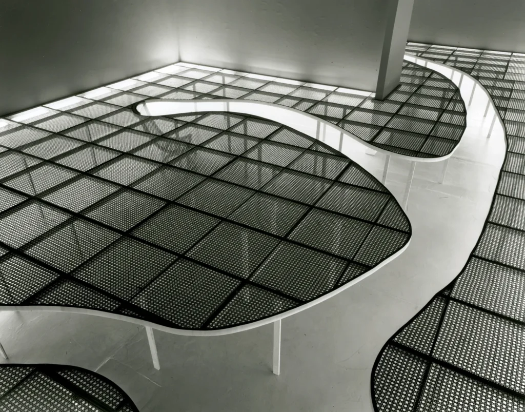 Modern white sculptural artwork extending across the gallery floor.