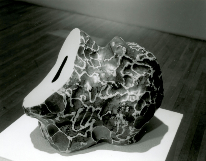 Black and white photo of a sculpture with waves on a table.