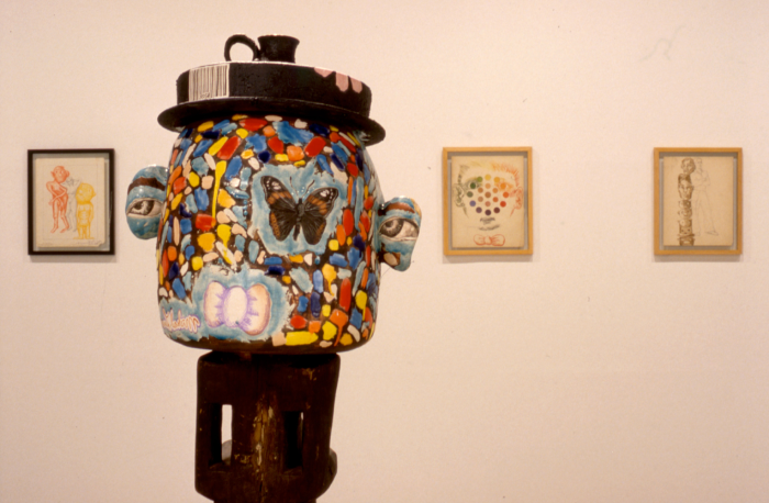 Photo of a colorful pot eith a black lid.