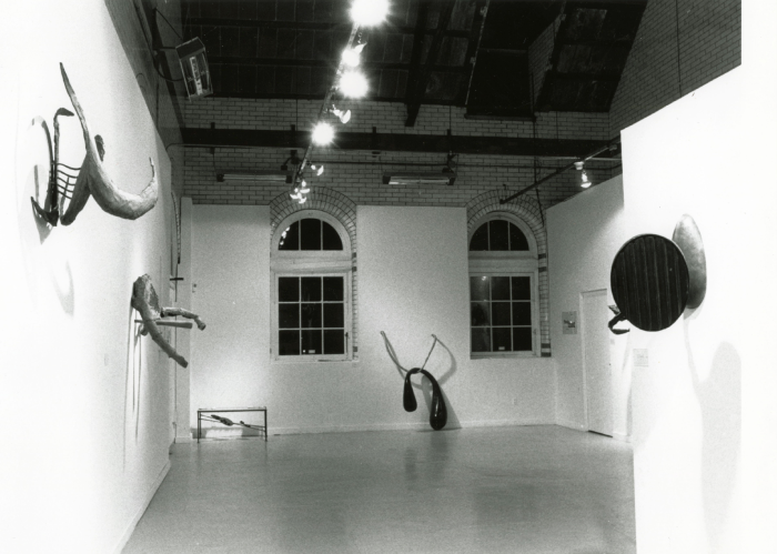 Black and white photo of metal scultures hanging on the walls