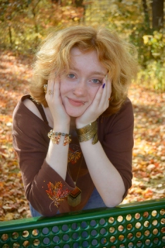 Honors Convocation 2026 award recipient Sophie Ward smiles and leans against a green bench outside in the fall.