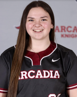 Honors Convocation 2026 award recipient Taylor Migliore stands in front of an Arcadia Knights-themed backdrop while wearing an Arcadia jersey and smiles.