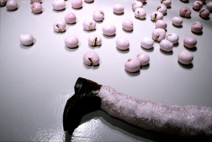 Photo of a leg with lace and small pink balls with teeth.