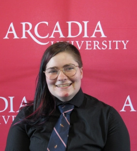 Honors Convocation 2026 award recipient Theo Osborn stands in front of an Arcadia-themed backdrop and smiles.