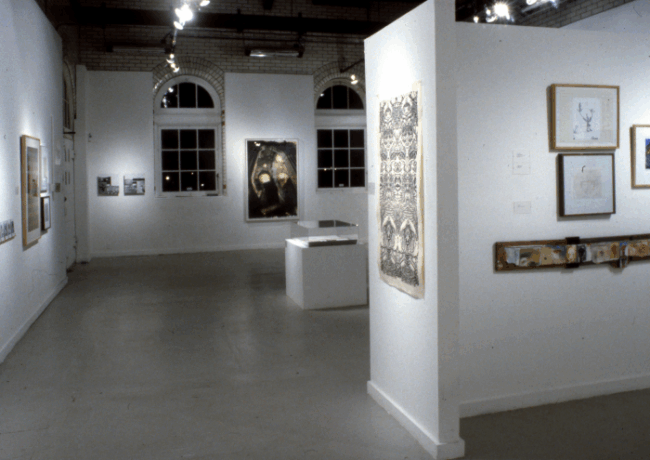 Photo of a white room with paintings hanging on the walls