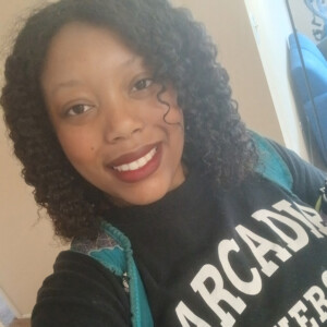 Raine Robinson ’24, ’26MPH poses in an Arcadia University shirt.
