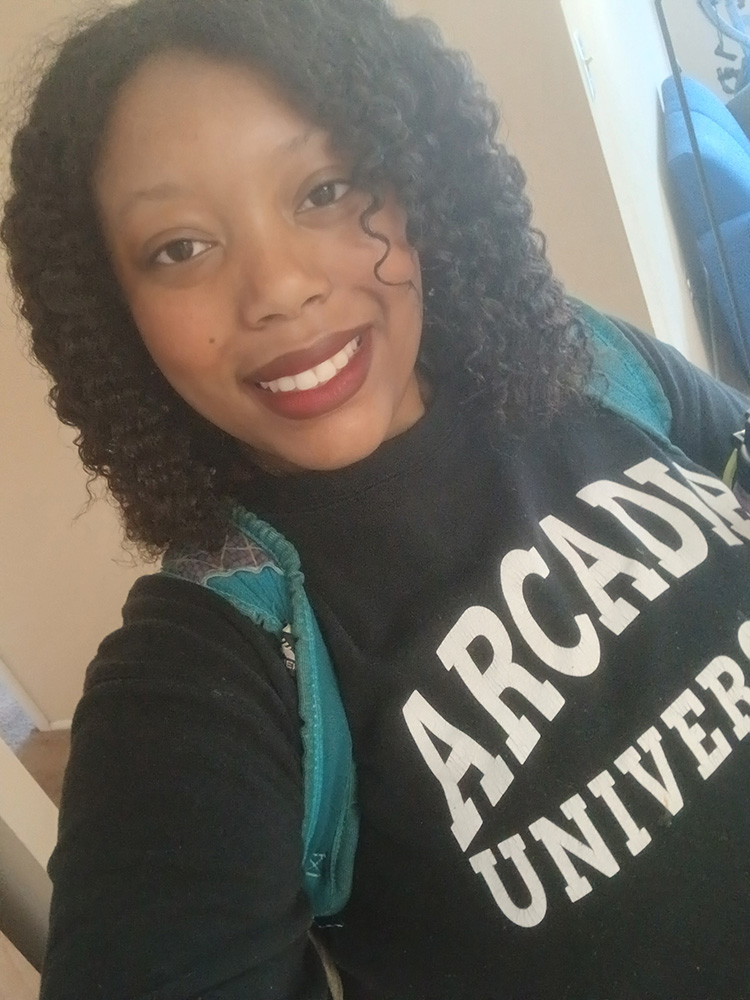 Raine Robinson ’24, ’26MPH poses in an Arcadia University shirt.