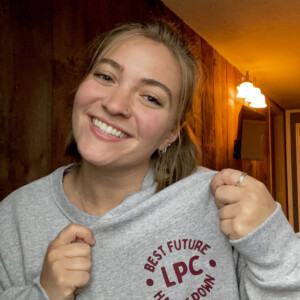 Emma Woehr ’26M wearing a sweatshirt that says "Best Future LPC Hands Down"