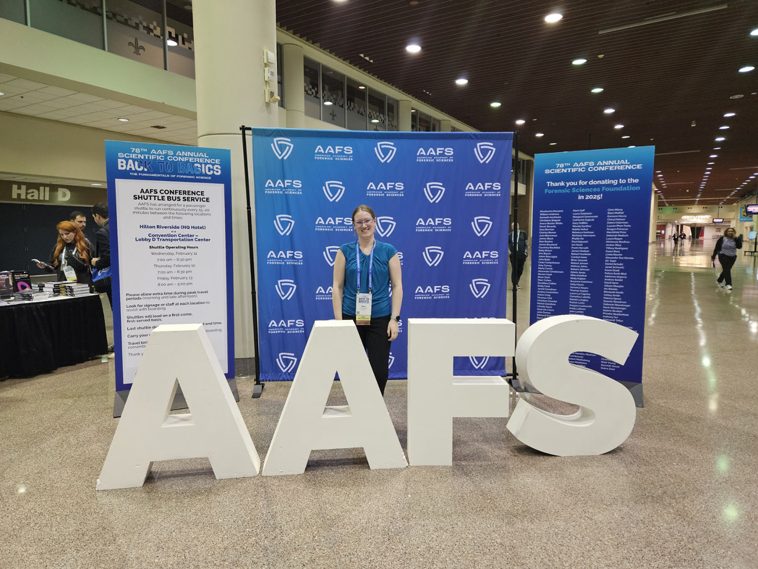 Mary Matya ’26M standing behind an "AAFS" sign.