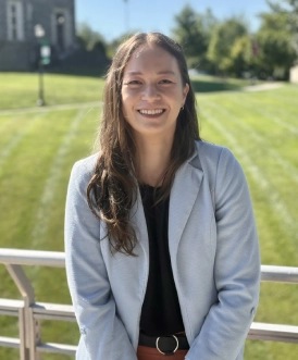 Honors Convocation 2026 award recipient Anne Leung leans on a metal railing and smiles with the Haber Green visible behind her.