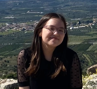 Honors Convocation 2025 award recipient Peri Oberman smiles atop a cliff.