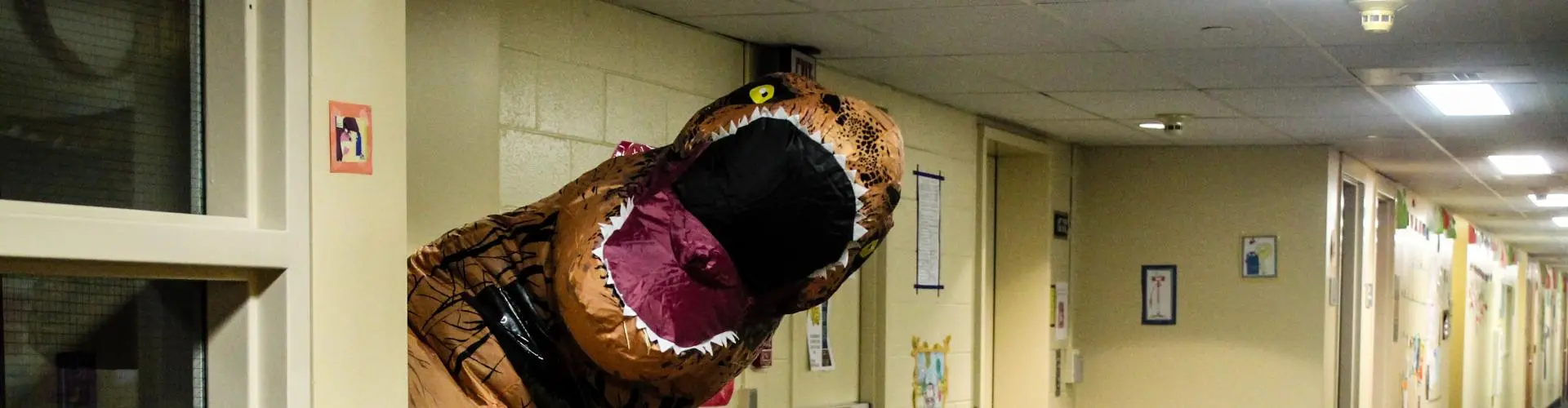 An inflatable t-rex head pops our from a resident hall room door