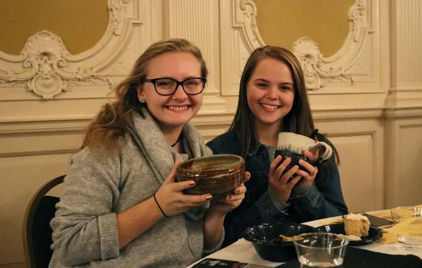 Two students hold ceramic bowls during the annual Empty Bowl event