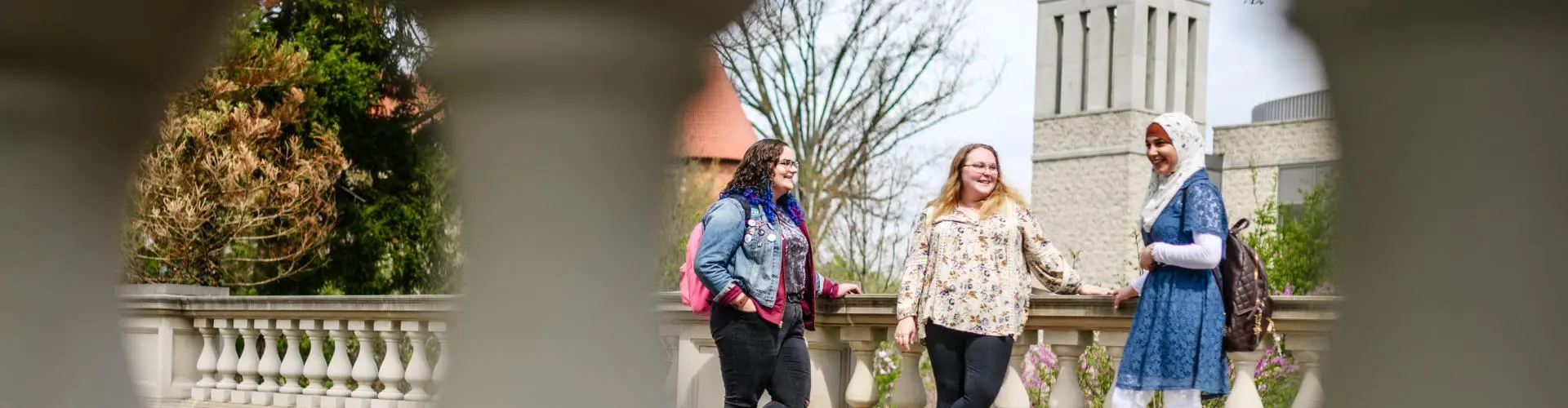 Three female students talk outside on Arcadia University campus