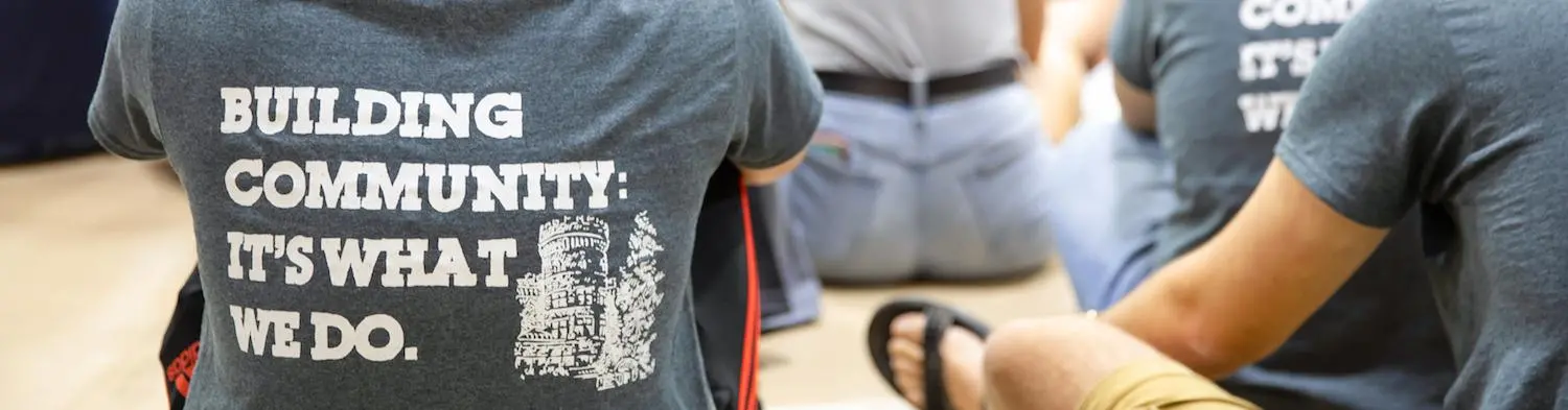 A photo of the back of a shirt that reads Building Community: It's What We Do.