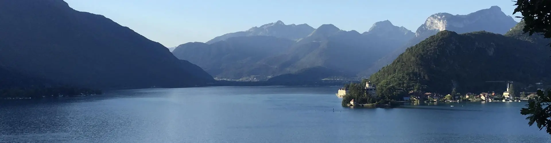 A large body of water with grassy mountains in the background