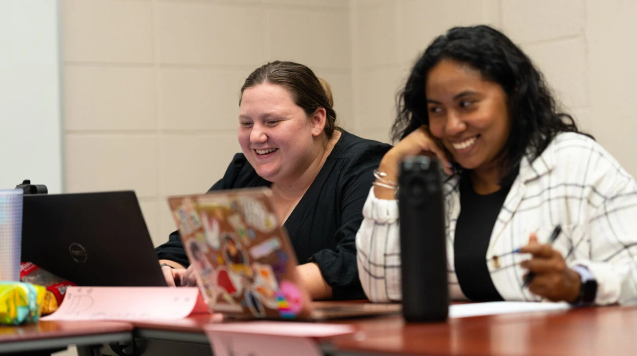 Grad students smile in an education classroom.