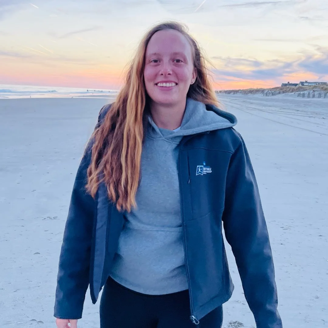 Woman standing on a beach wearing two hoodies
